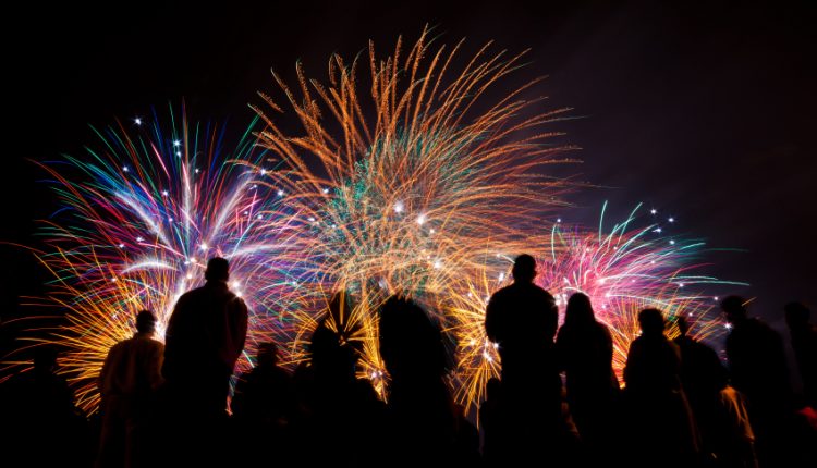 Big fireworks with silhouettes of people watching it